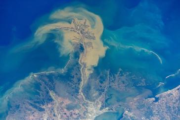 An aerial shot of discolored yellow water moving into the darker blue of the Gulf of Mexico. 
